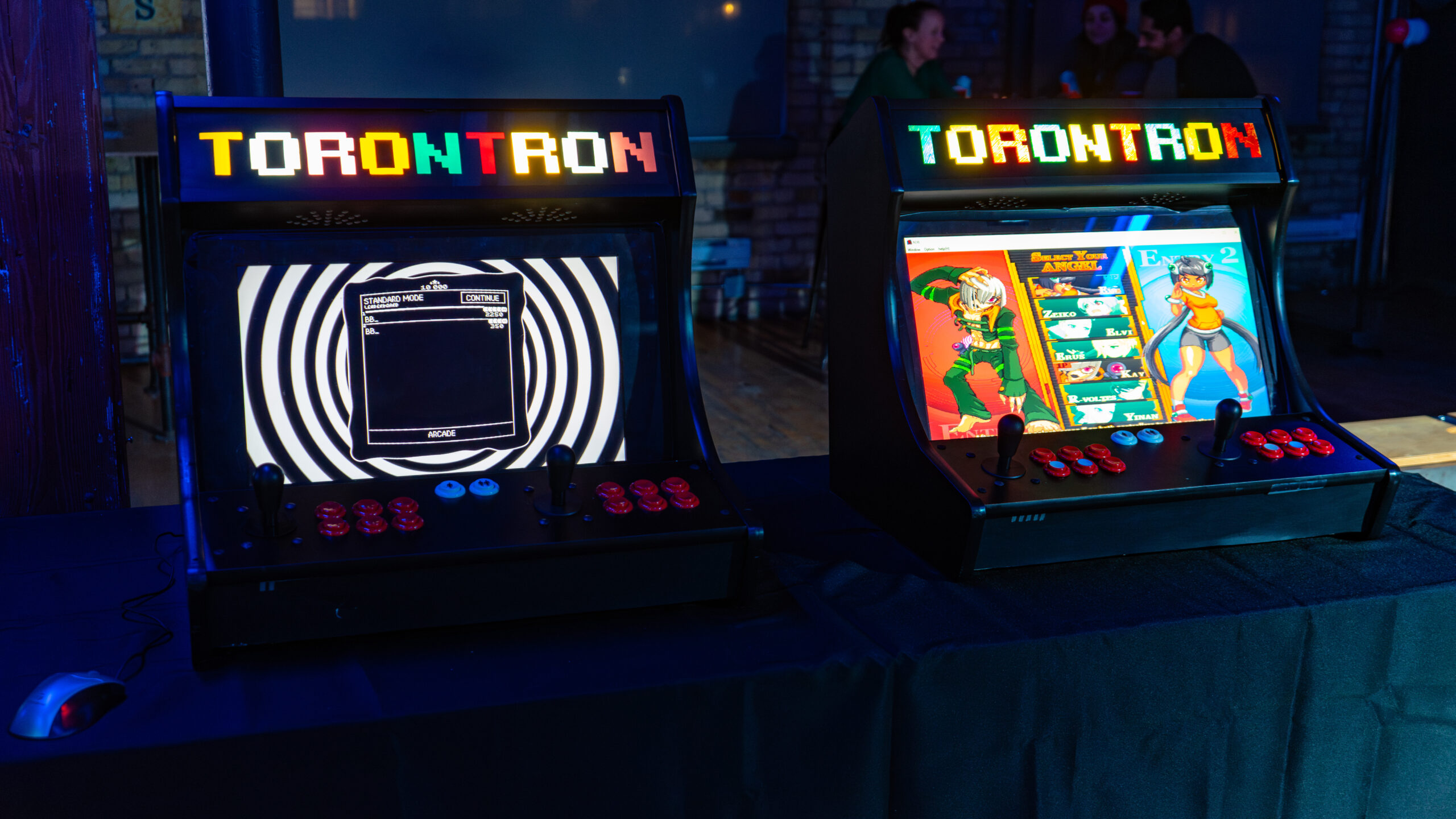 Two Mini Arcade Cabinets placed side by side in a low lit room